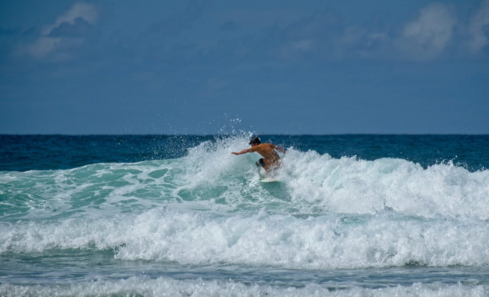 man surfing on sea waves during daytime
